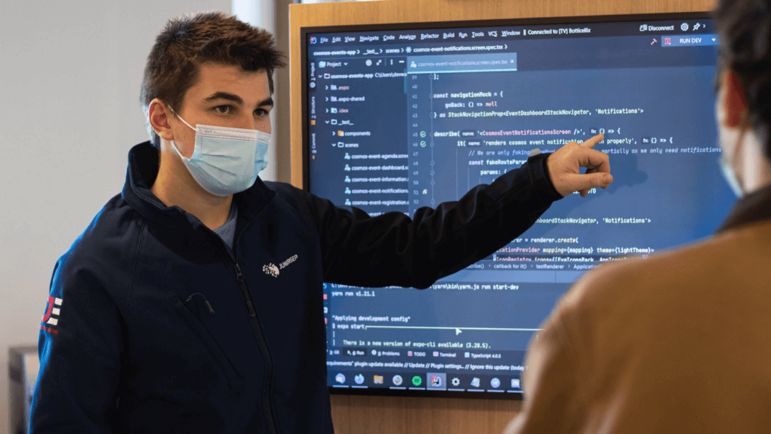 Man pointing at screen with code on 