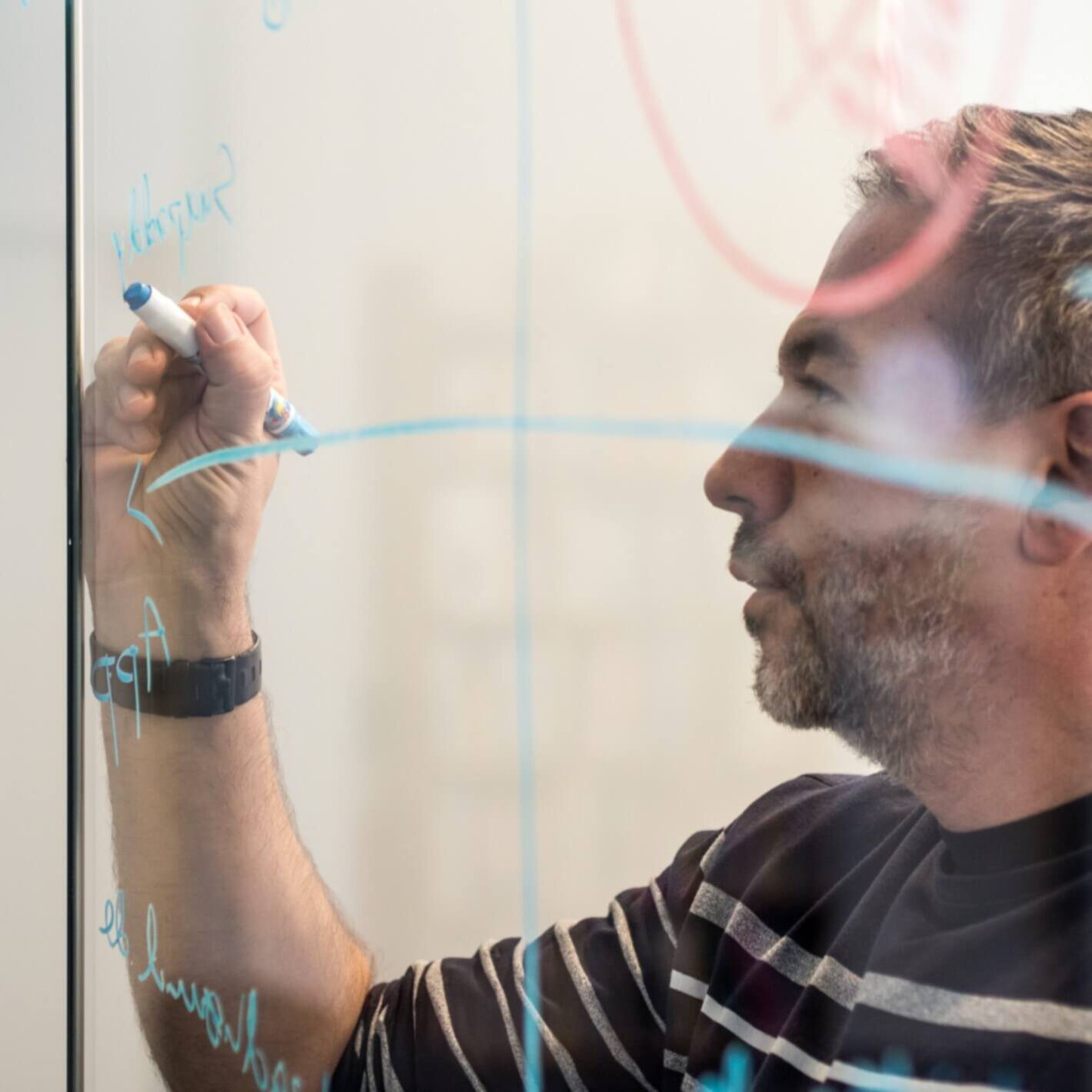 man drawing on glass