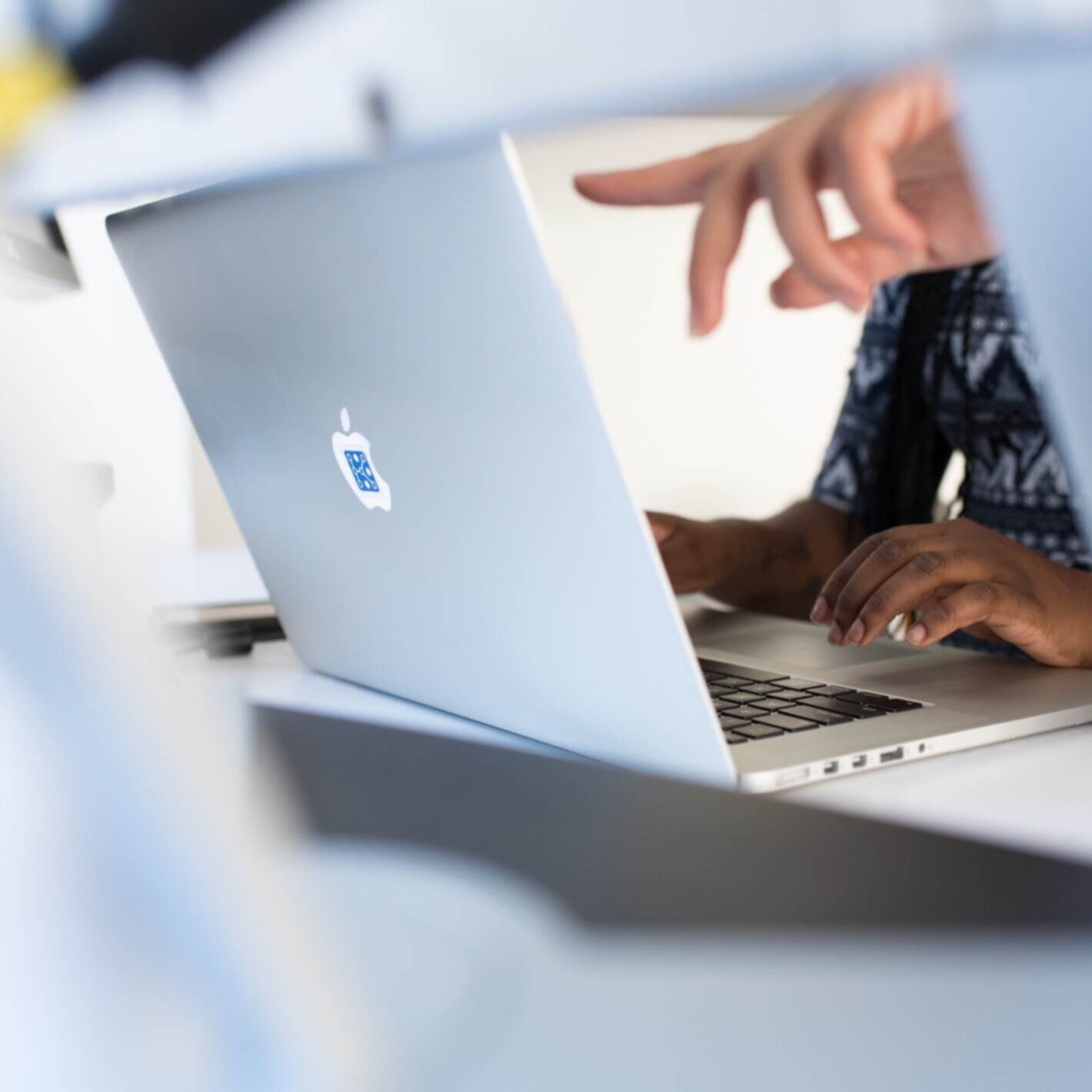 Mac laptop and a finger pointing