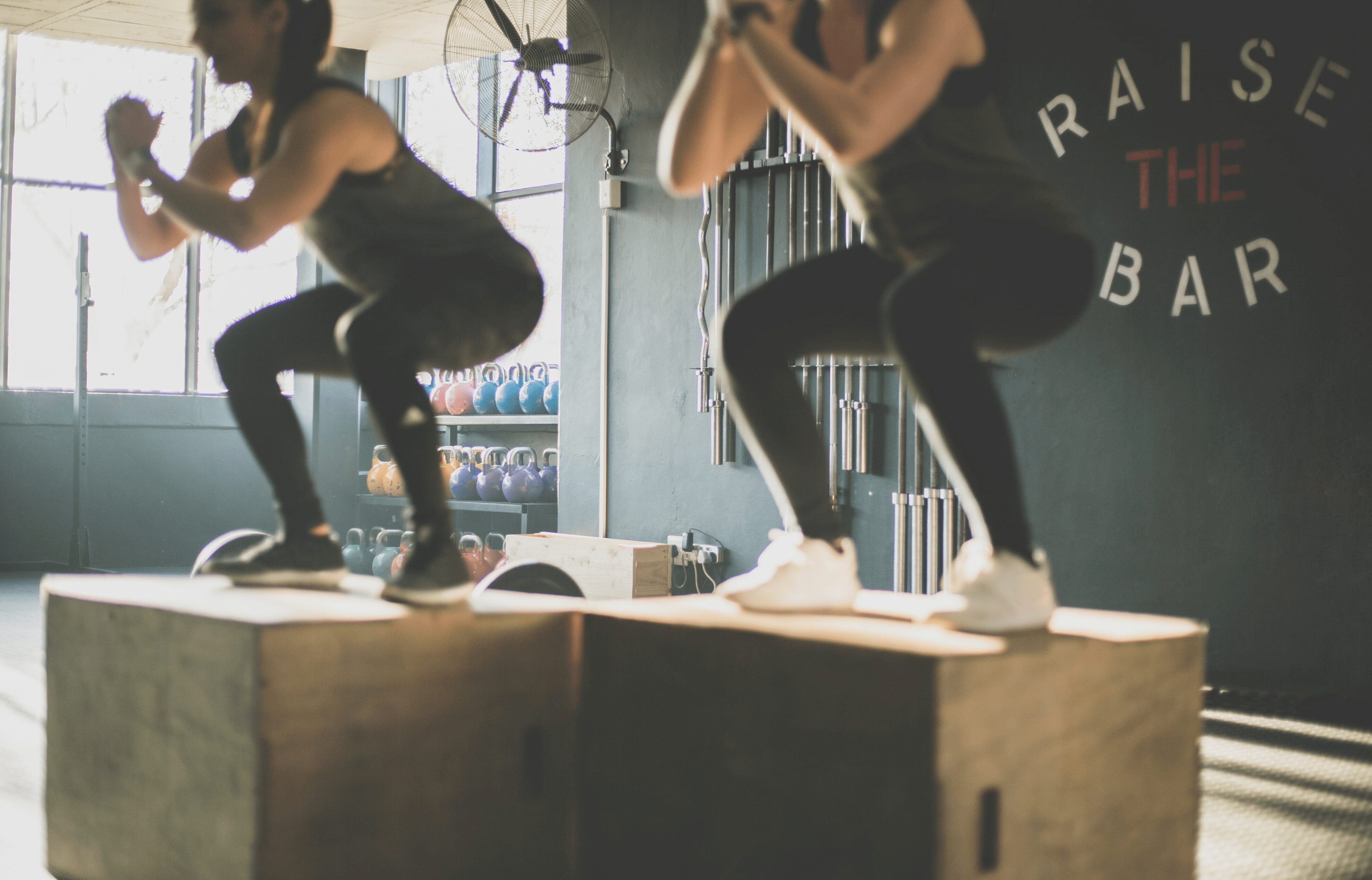 Two people squatting in gym class