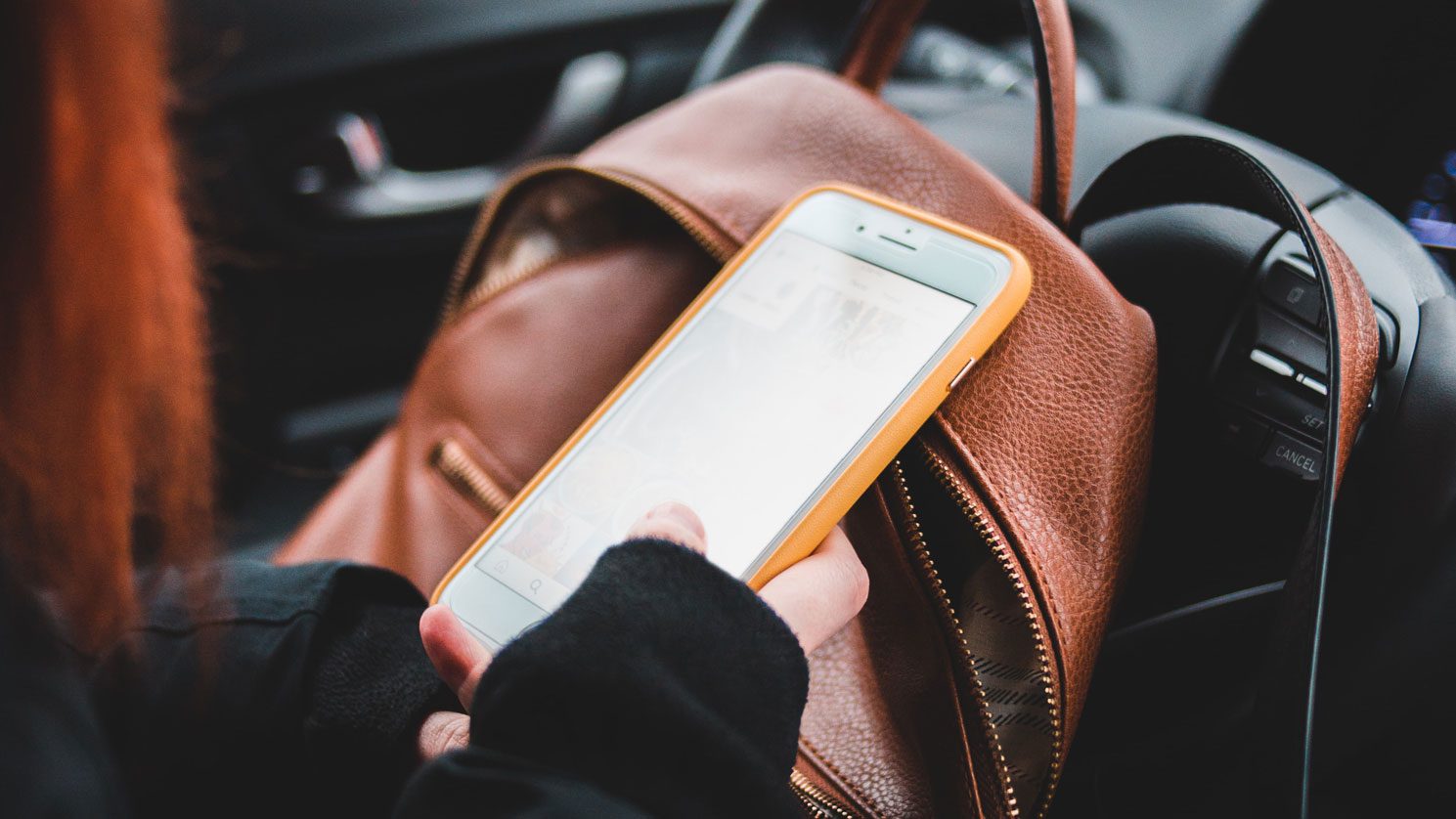 Woman looking at mobile phone in car