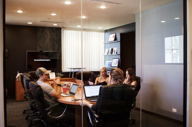 Group of people in a meeting room looking at laptops