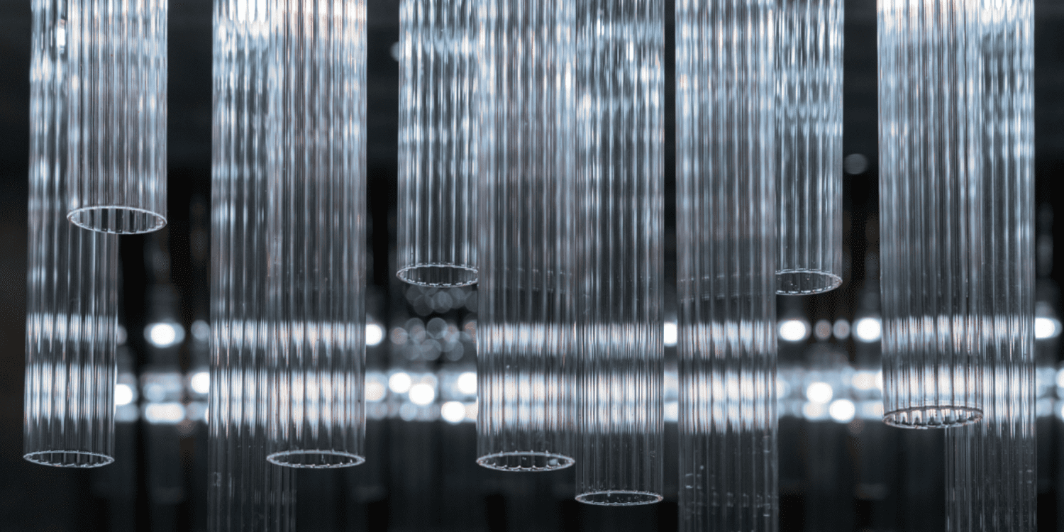 Multiple glass tubes hanging from the ceiling in a chandelier type way